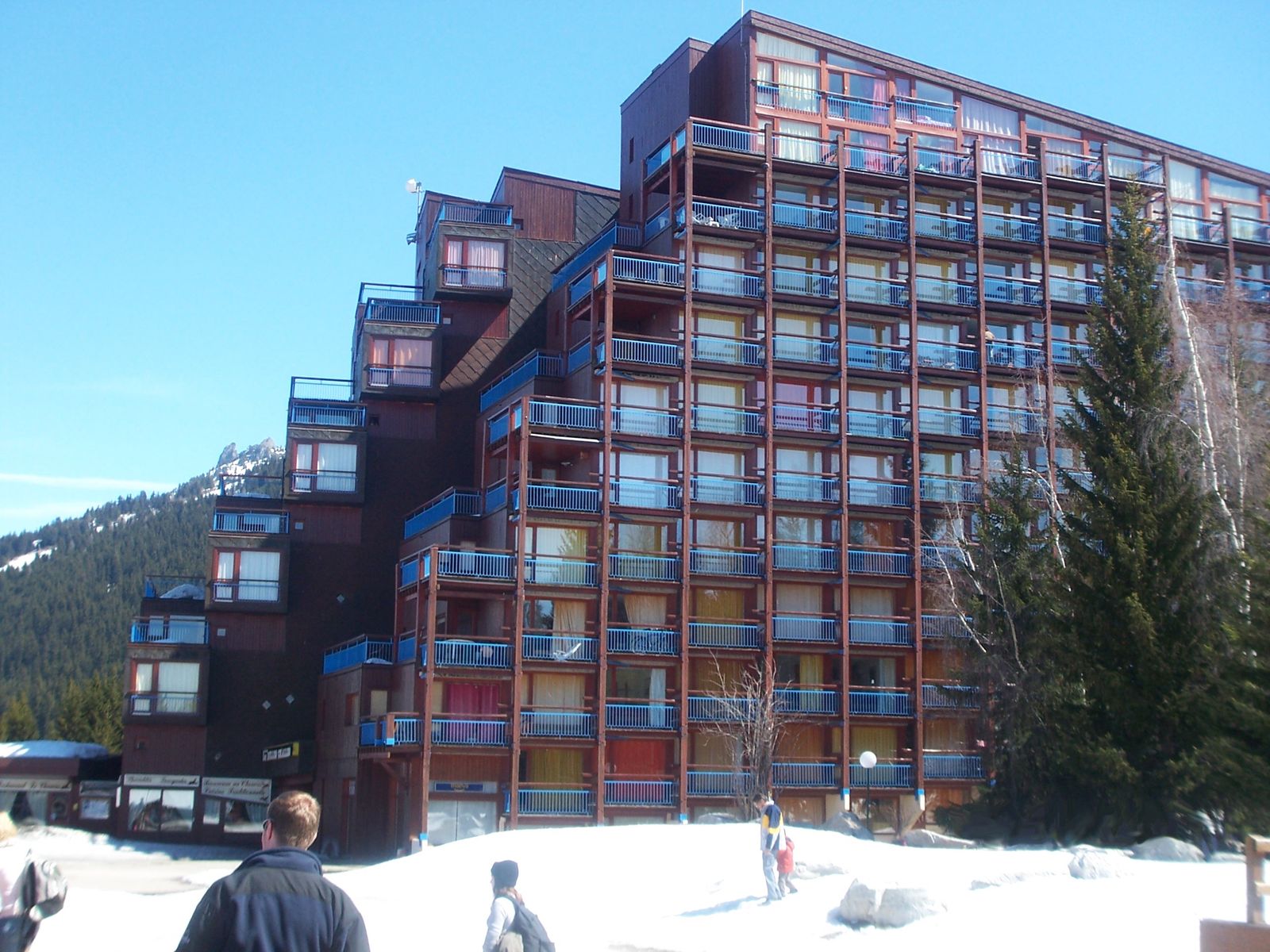Prédio escalonado de Les Arcs encostado na montanha, com pinheiros