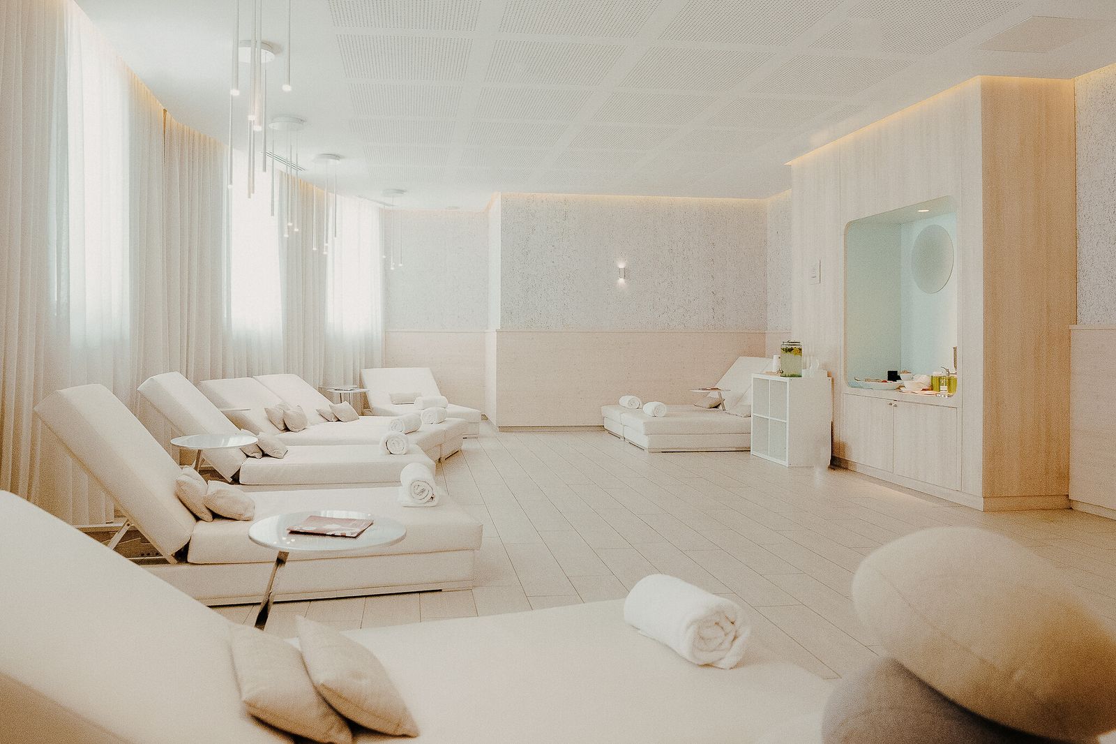 Sala de relaxamento do spa, toda branca, com espreguiçadeiras